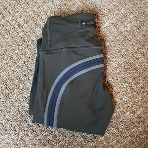 Dark green Lululemon leggings with shades of green stripe going down sides